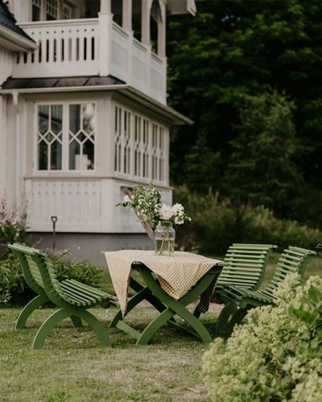 Sekelskifteskänsla på verandan med trädgårdsmöbler i massivt trä