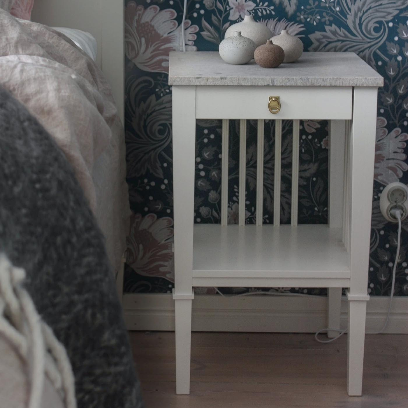 Sängbordet står bredvid en säng i ett harmoniskt sovrum