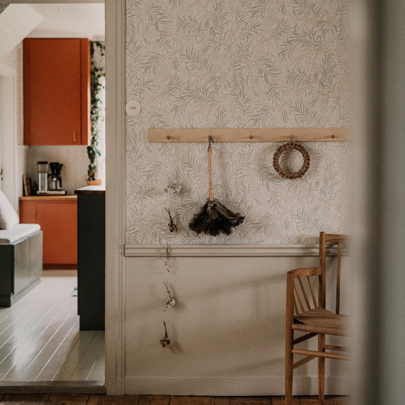 Knopplist i björk på vägg bredvid dörröppning, med hängande föremål 