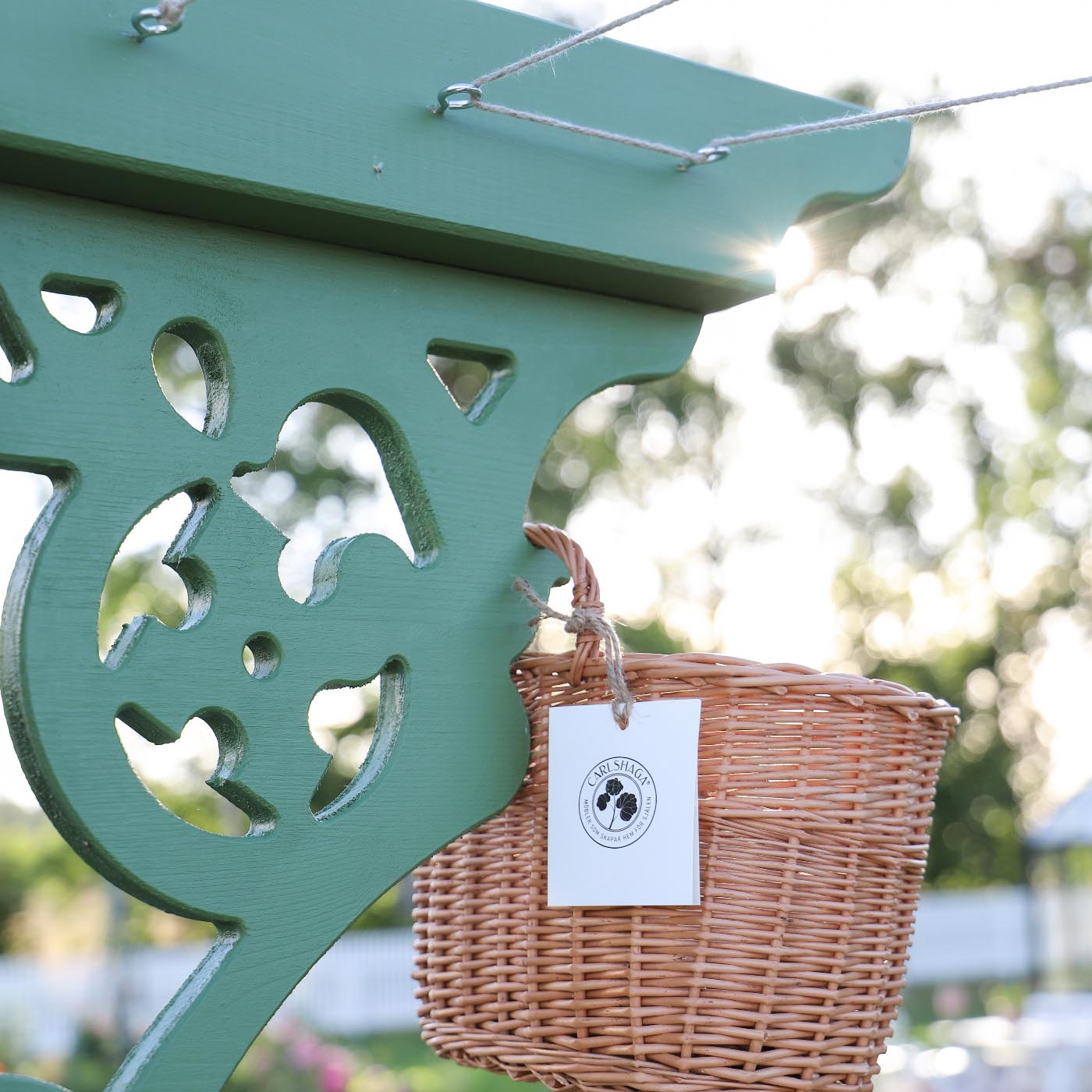 Liten väggkorg i pil hängande på torkställning utomhus 